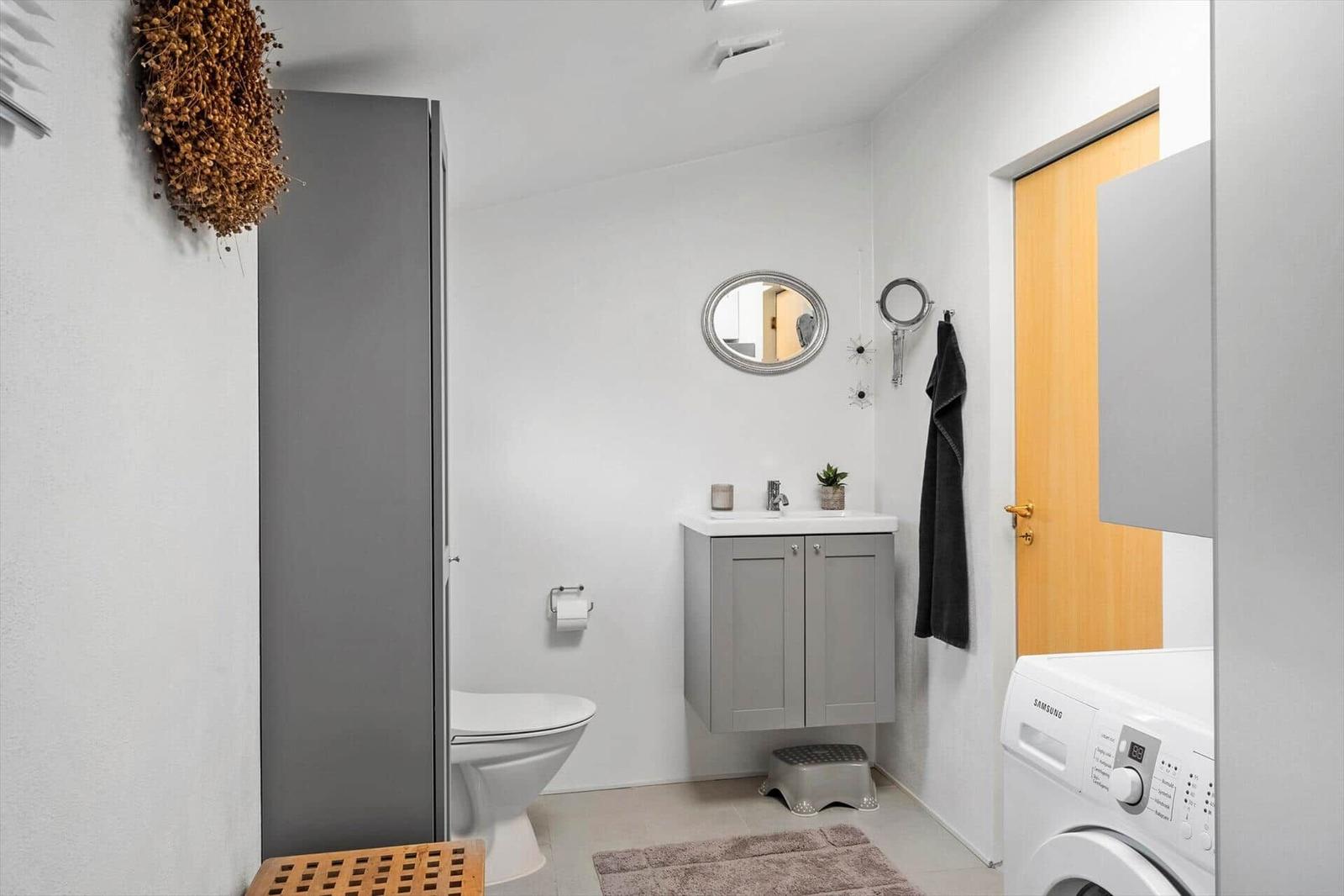 Badezimmer mit Toilette, Waschbecken und Waschmaschine.