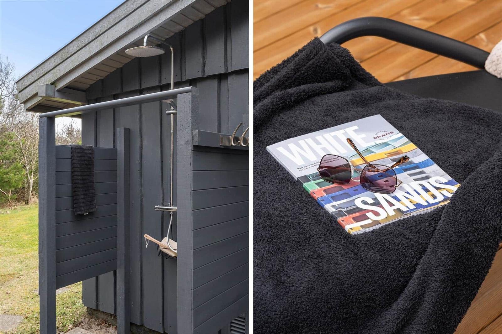 Außen-Dusche mit Duschbrause und Handtuch. Schwarzes Handtuch mit Sonnenbrille und Magazin.