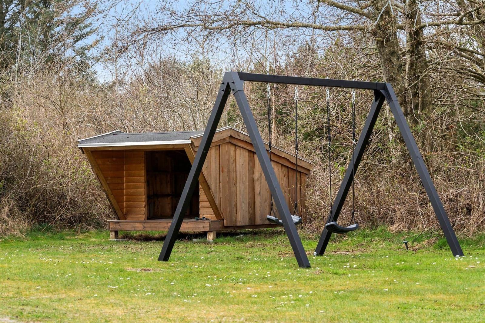 Holzschuppen mit Schaukel im Garten