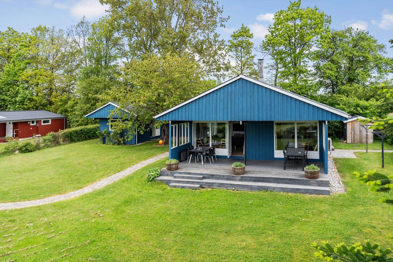 Blue vacation house with terrace and garden. View of living and dining area.