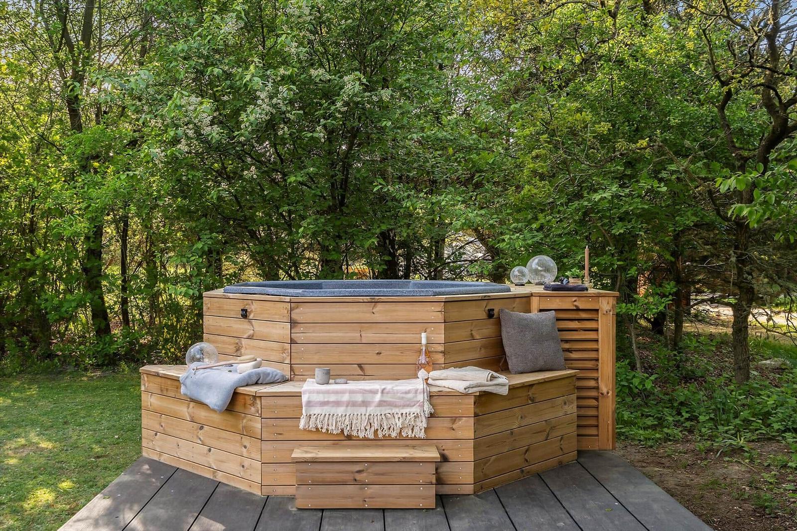 Holzkonstruktion mit Whirlpool, Sitzbank und Decke im Wald