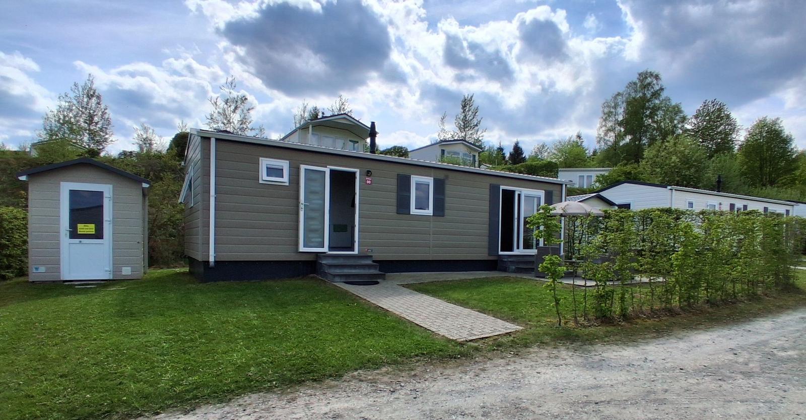Modernes Ferienhaus mit Terrasse und Garten. Nebenhaus mit Tür.