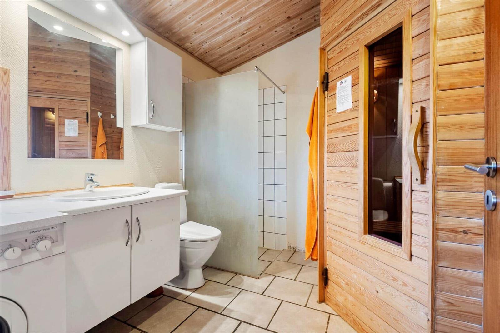 Schlafzimmer mit Holzwand, Bett, Schrank und Fenstern.