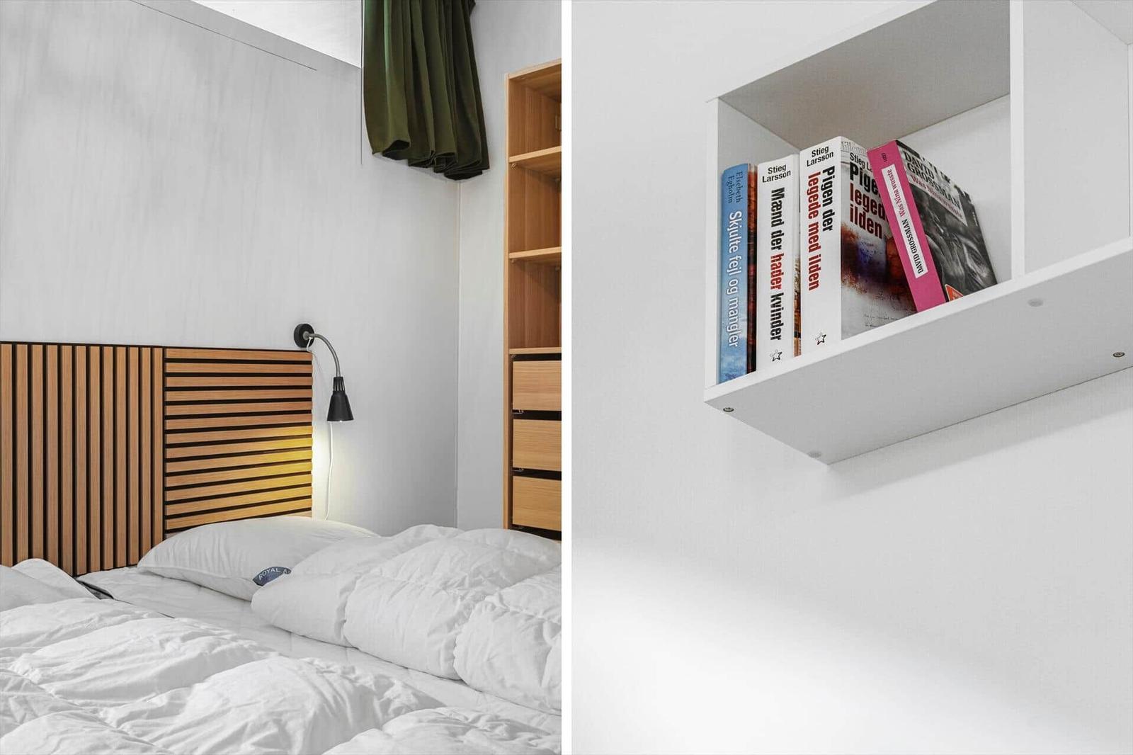 Schlafzimmer mit Holzbett und Bücherregal an der Wand.