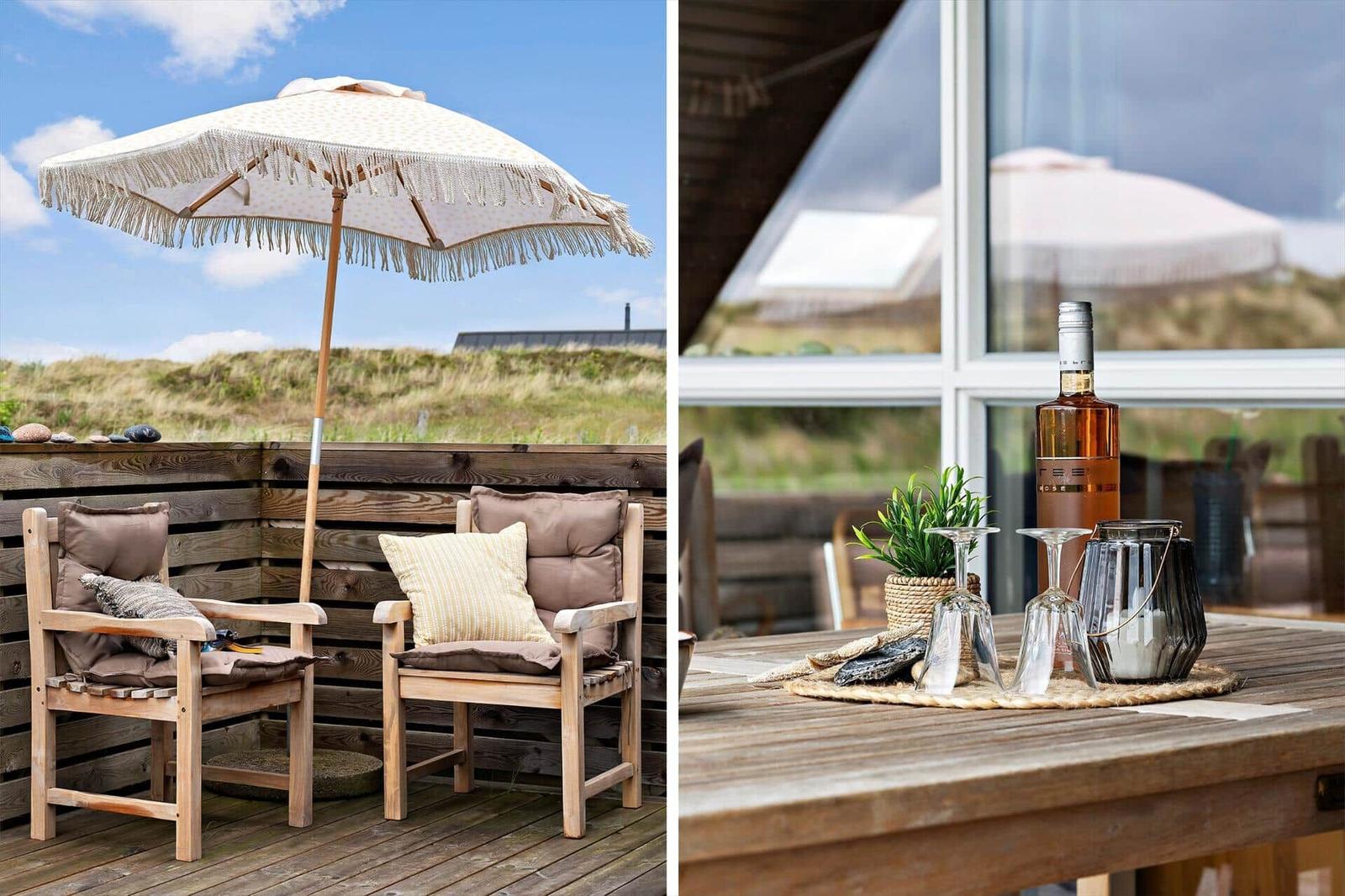 Terrasse mit Stühlen, Sonnenschirm und Blick auf Dünen