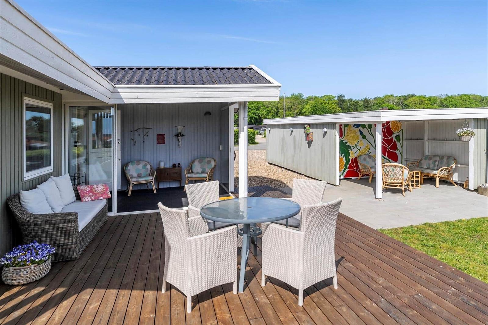 Terrace with seating group and table. Rear yard with seating area and wall mural.