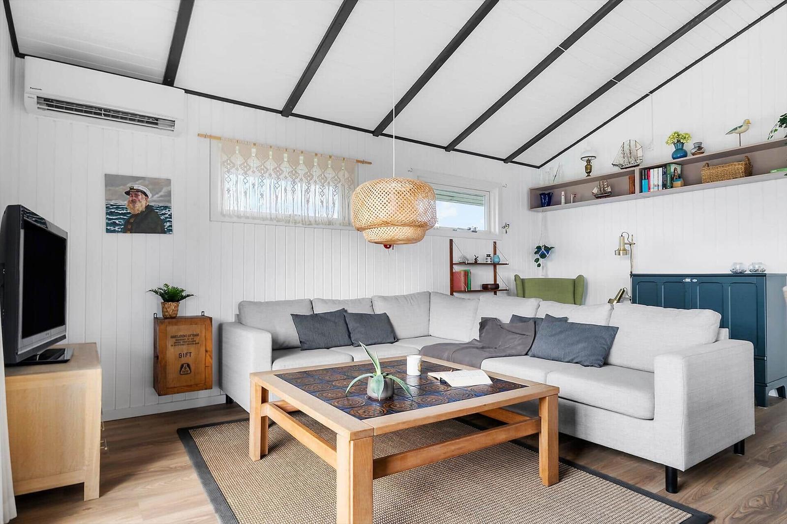 Living room with gray sofa, wooden table, and ceiling fan.