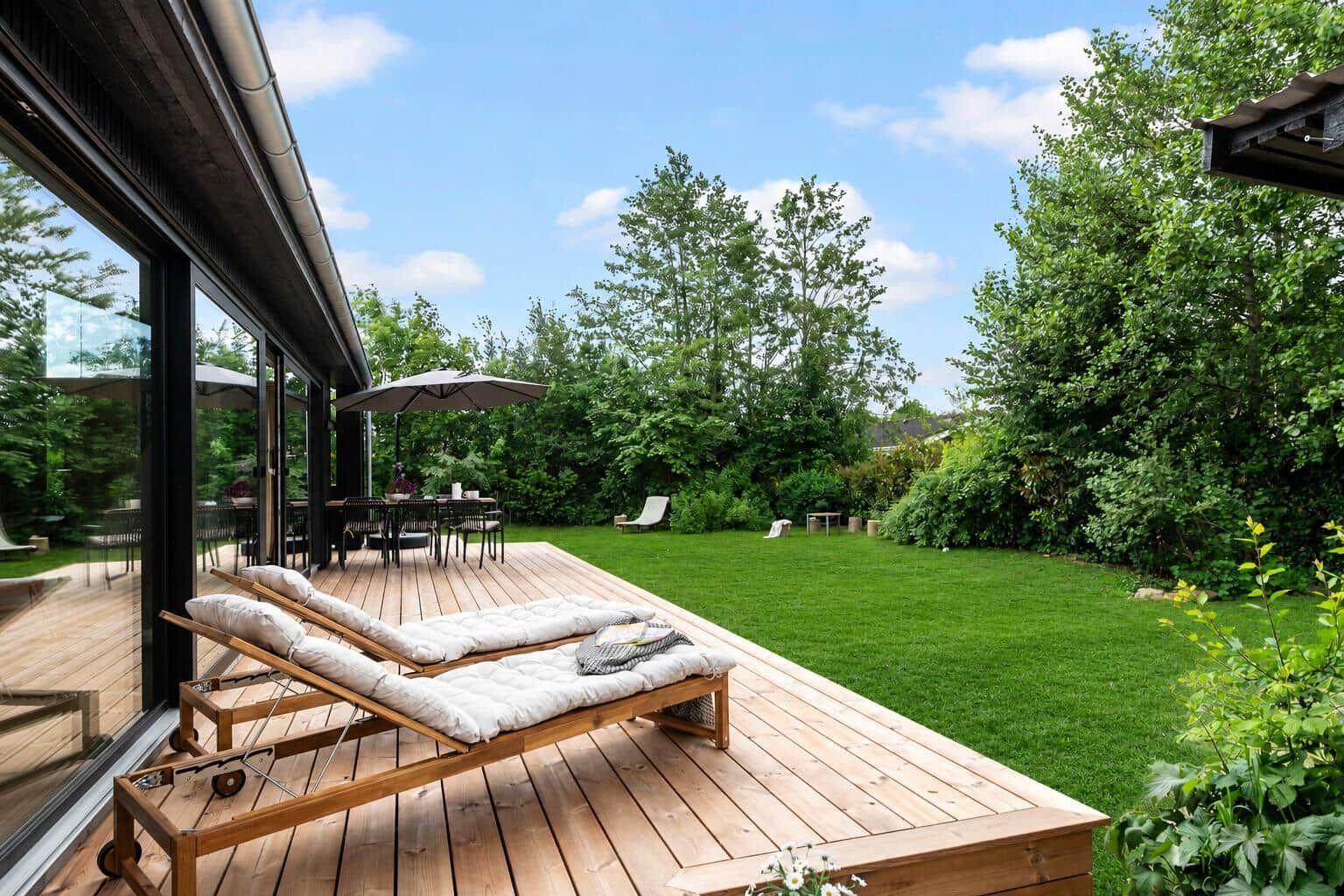 Deck with lounge chairs and grill area in the green.