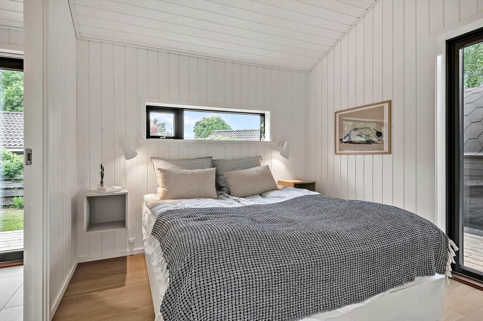 Bedroom with bed, window, and door to terrace.