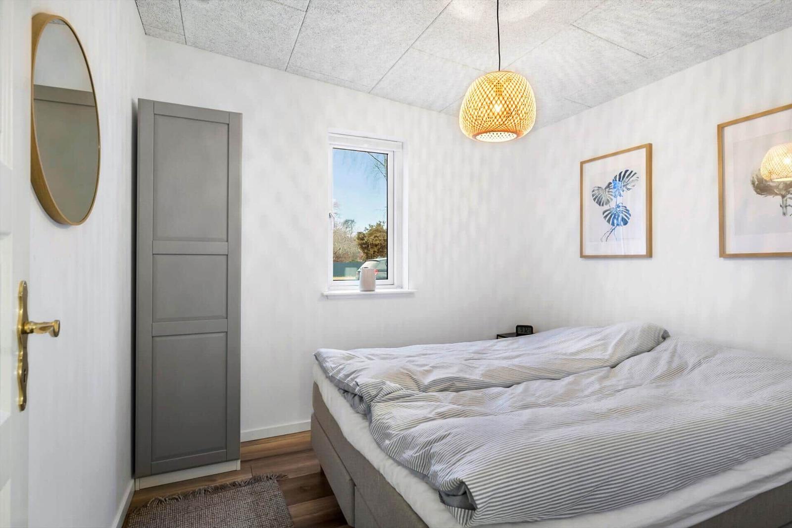 Bedroom with bed, window, and ceiling light.