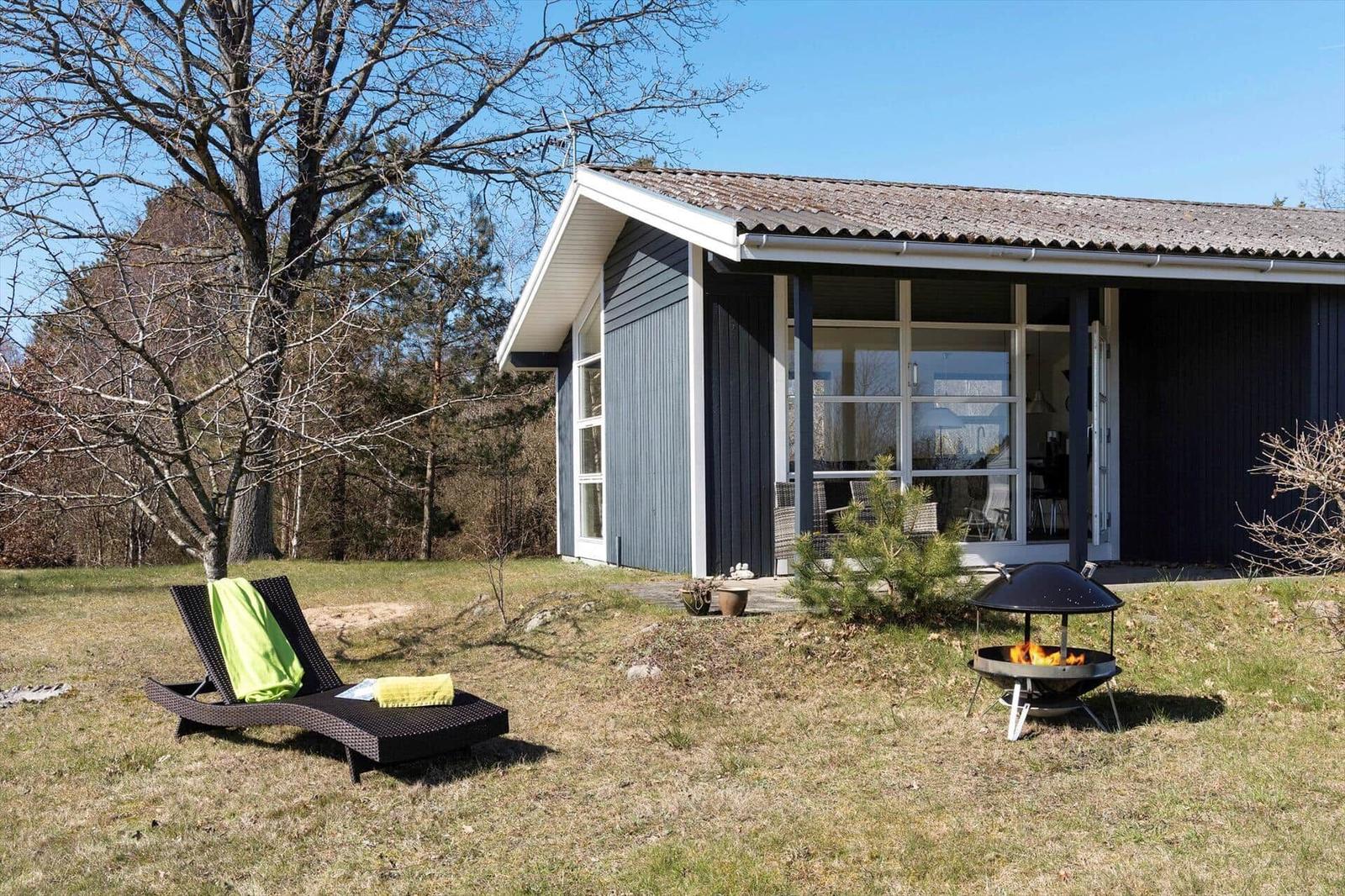 Moderne Villa mit Garten, Liegestuhl und Feuerkorb. Blick in die Wohnküche.