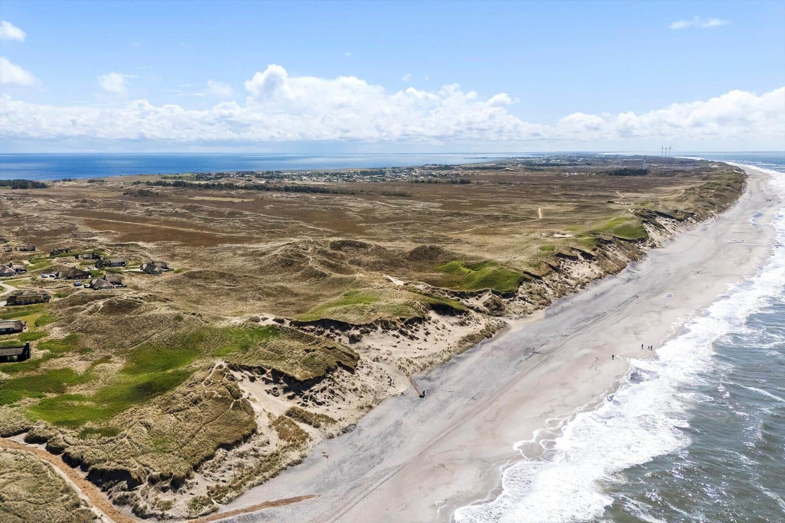 Beach with dunes and ocean view. Holiday home near the water.