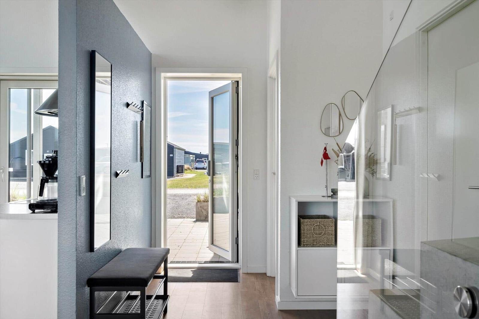 Haus mit offener Tür, Schrank und Spiegel an der Wand.