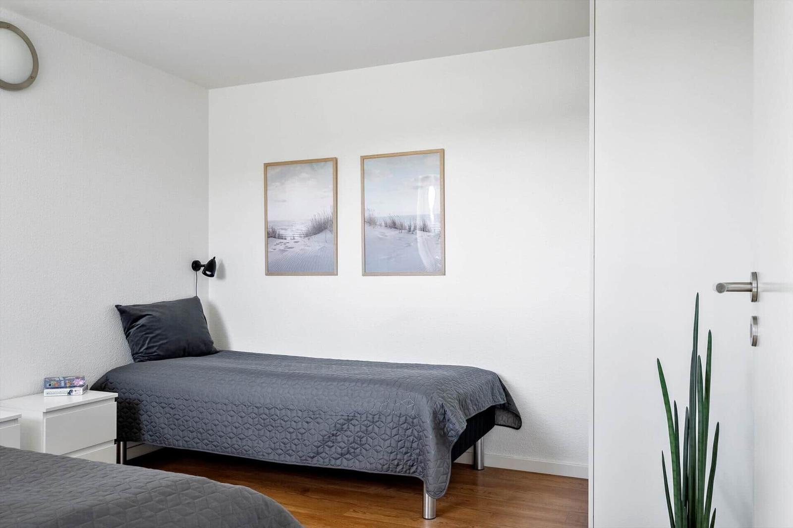 Schlafzimmer mit Bett, Nachttisch und Wandbildern