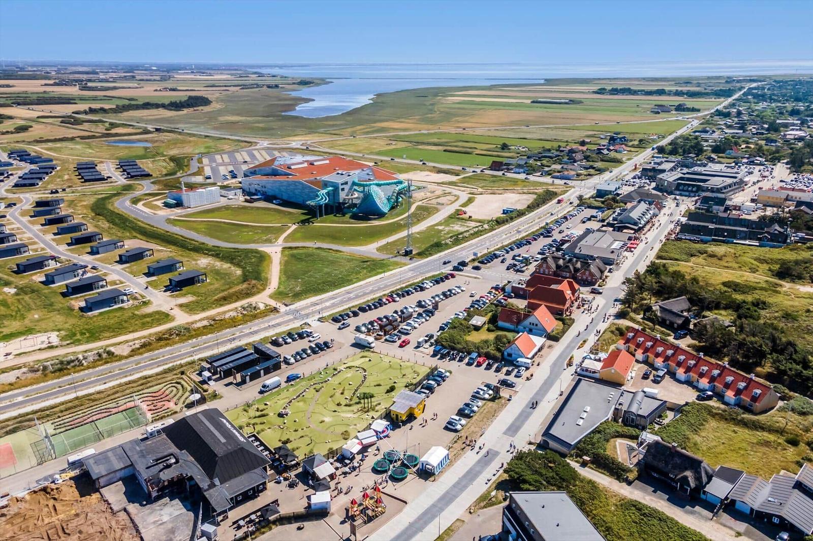 Luftbild einer Küstenstadt mit Hotels, Parkplätzen und einem Wasserpark.