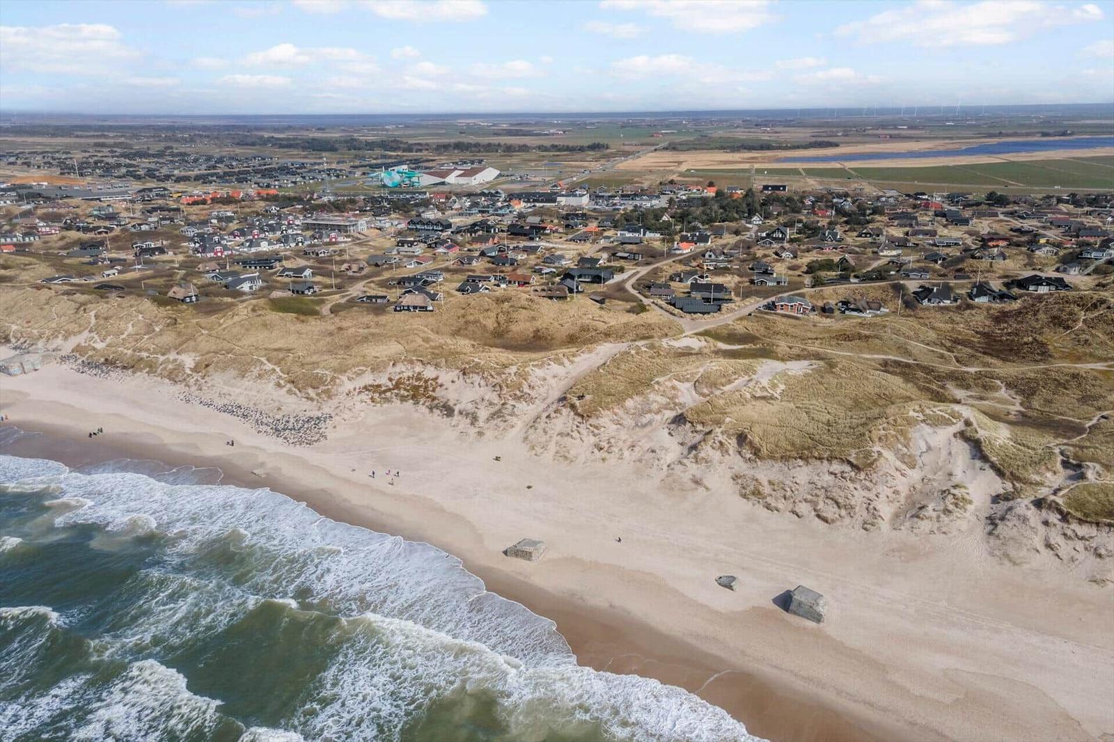 Aerielansicht einer Küstenstadt mit Strand, Dünen und Häusern