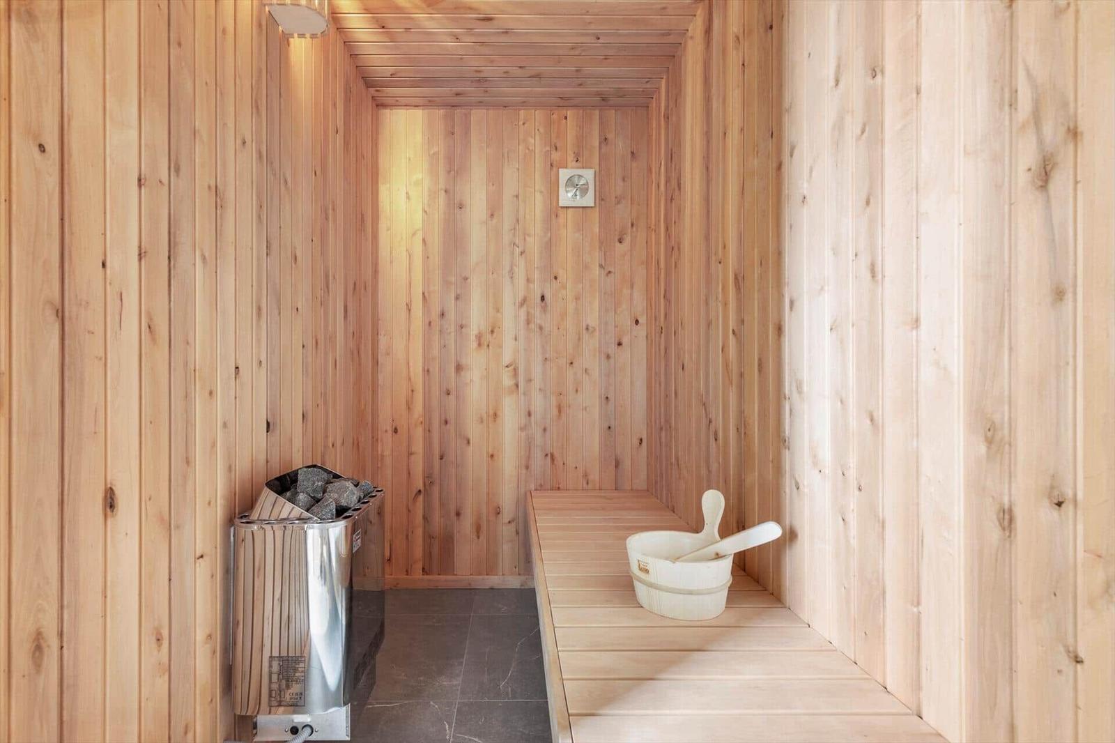 Sauna with wooden walls, bench, and bucket with ladle.