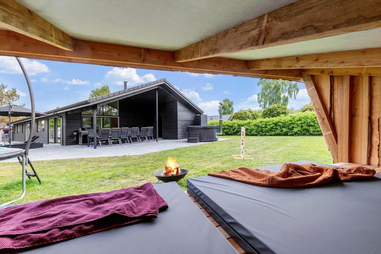 Outdoor area with loungers, fire pit, and view of the villa with terrace.