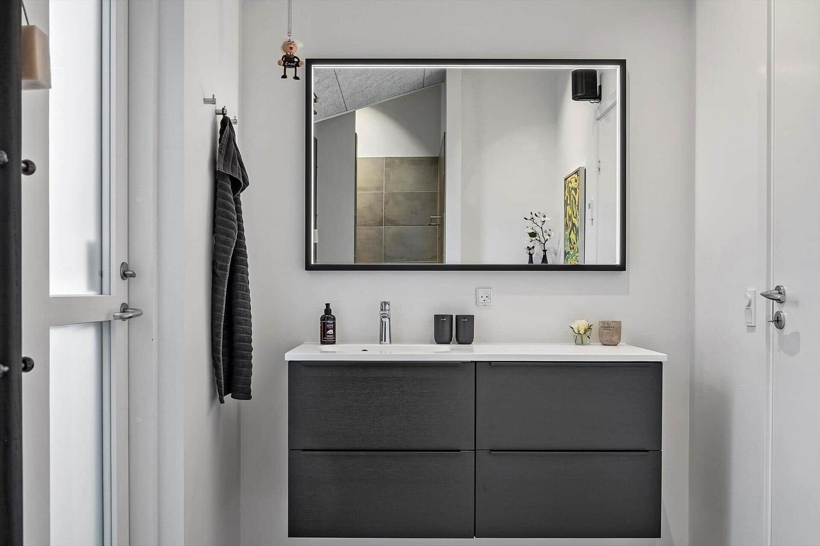 Badezimmer mit Spiegelschrank, Waschbecken und Dusche