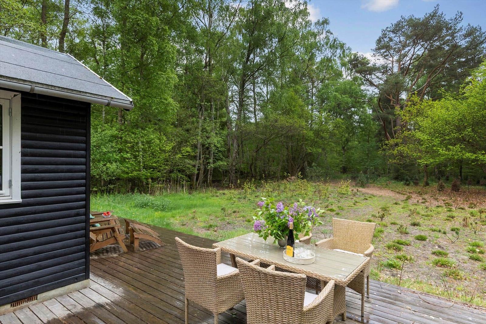 Terrasse mit Sitzgruppe und Blick in den Wald.