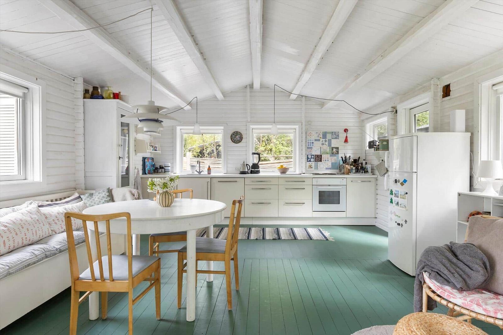Kitchen with dining area, green floor, and white built-in cabinetry.