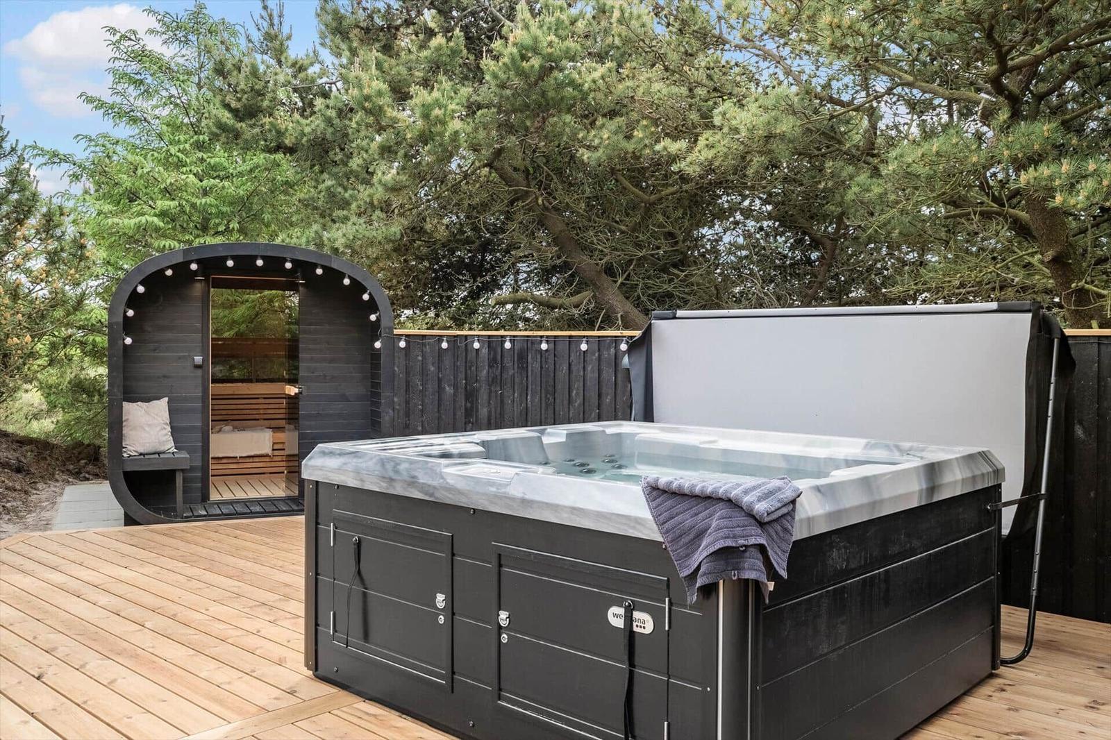 Hochwertige Außendusche mit Sauna und Holzterrasse im Grünen.
