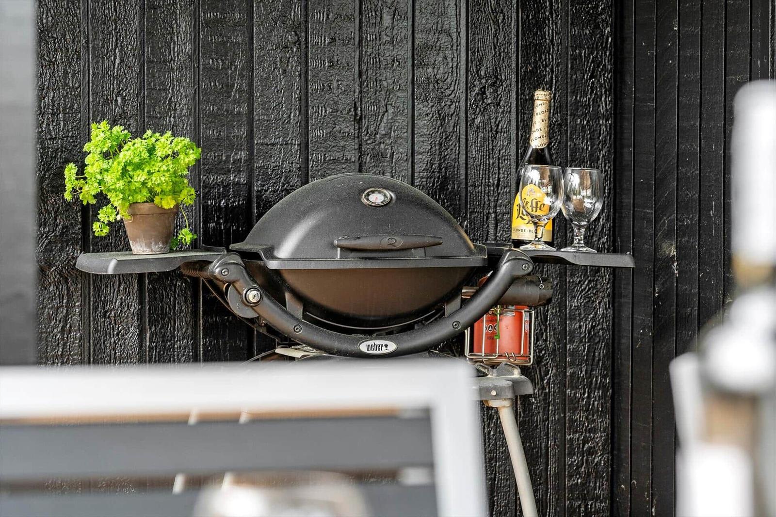 Gasherd mit Grill, Pflanze und Getränke auf der Terrasse.