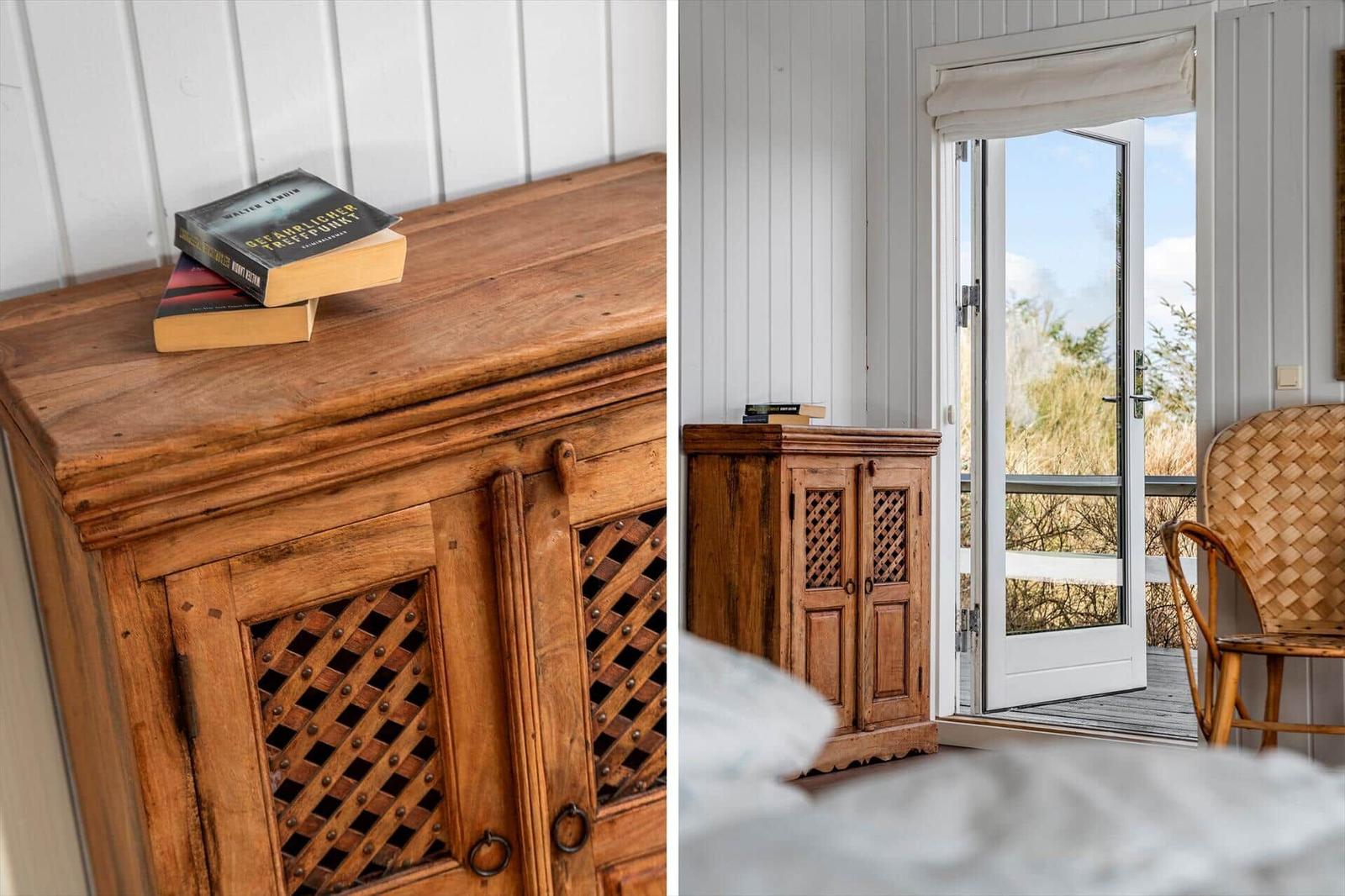 Holzschrank mit Bücherstapel, Tür zum Balkon mit Stuhl