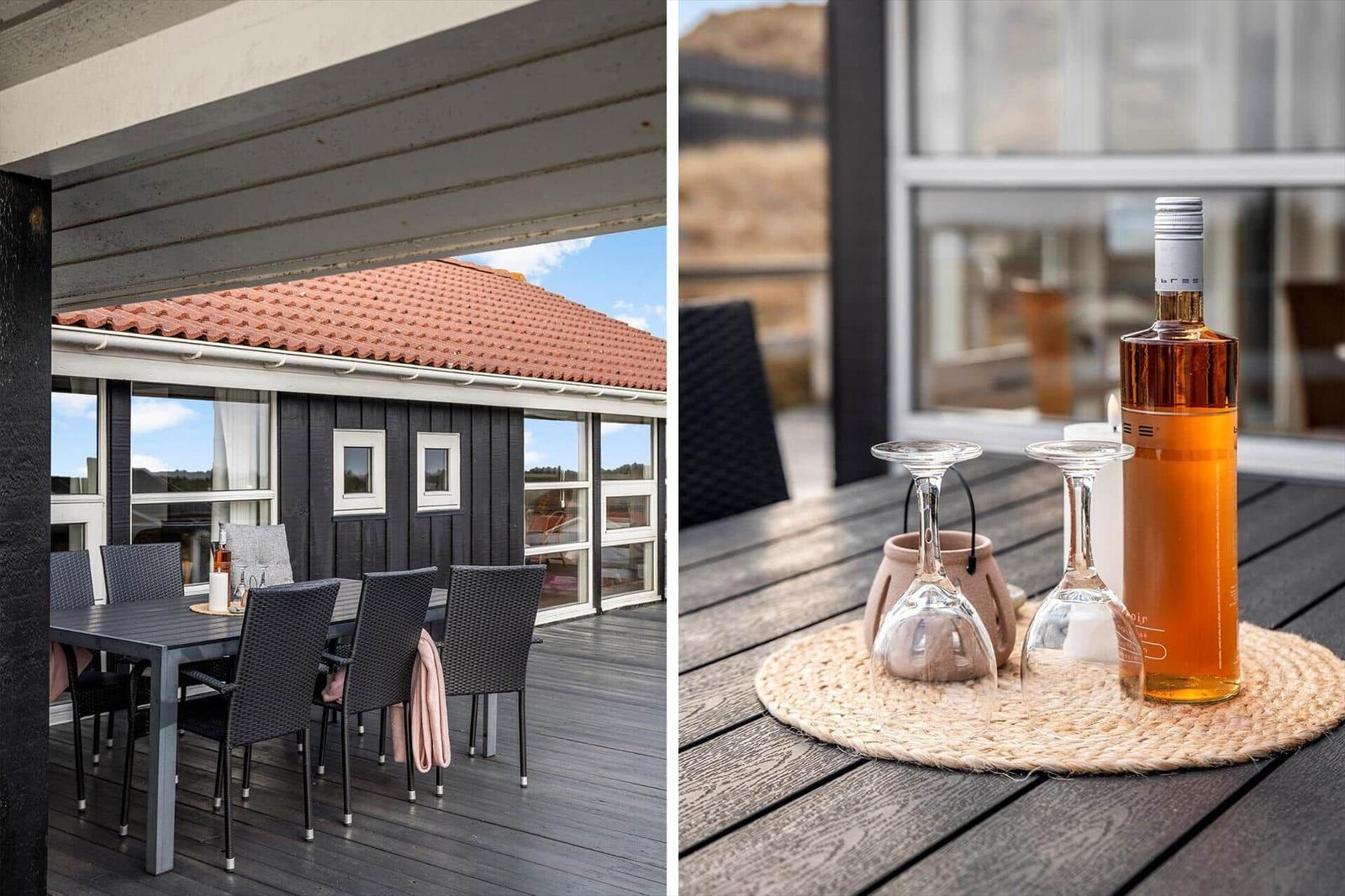 Terrasse mit Tisch und Stühlen. Flasche und Gläser auf Tisch.