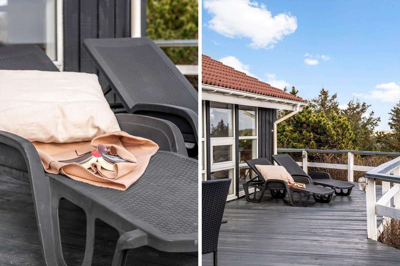 Terrasse mit Liegestühlen und Blick auf das Haus und die Umgebung.