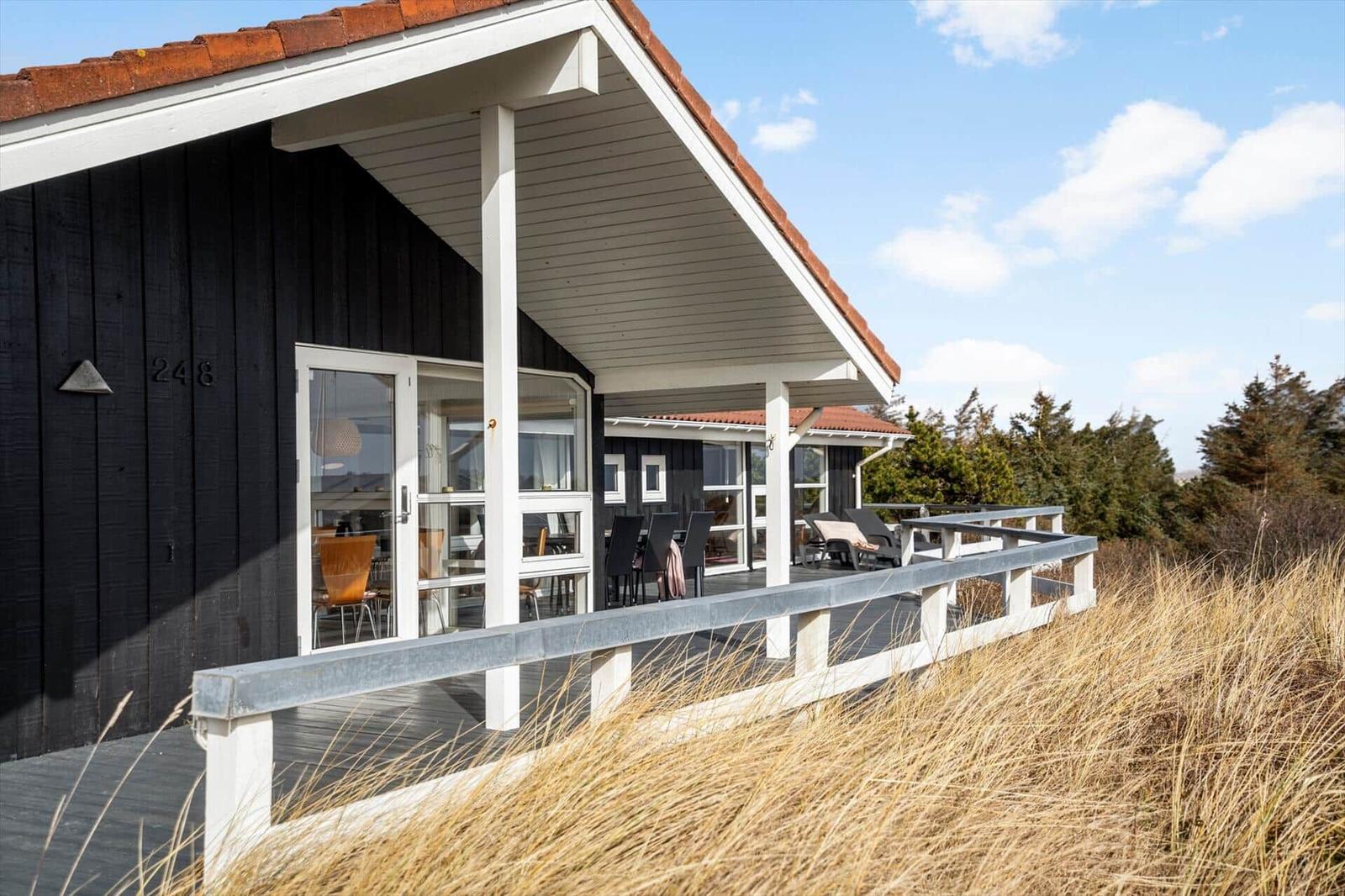 Moderne Villa mit Terrasse und Sitzgelegenheiten im Freien.