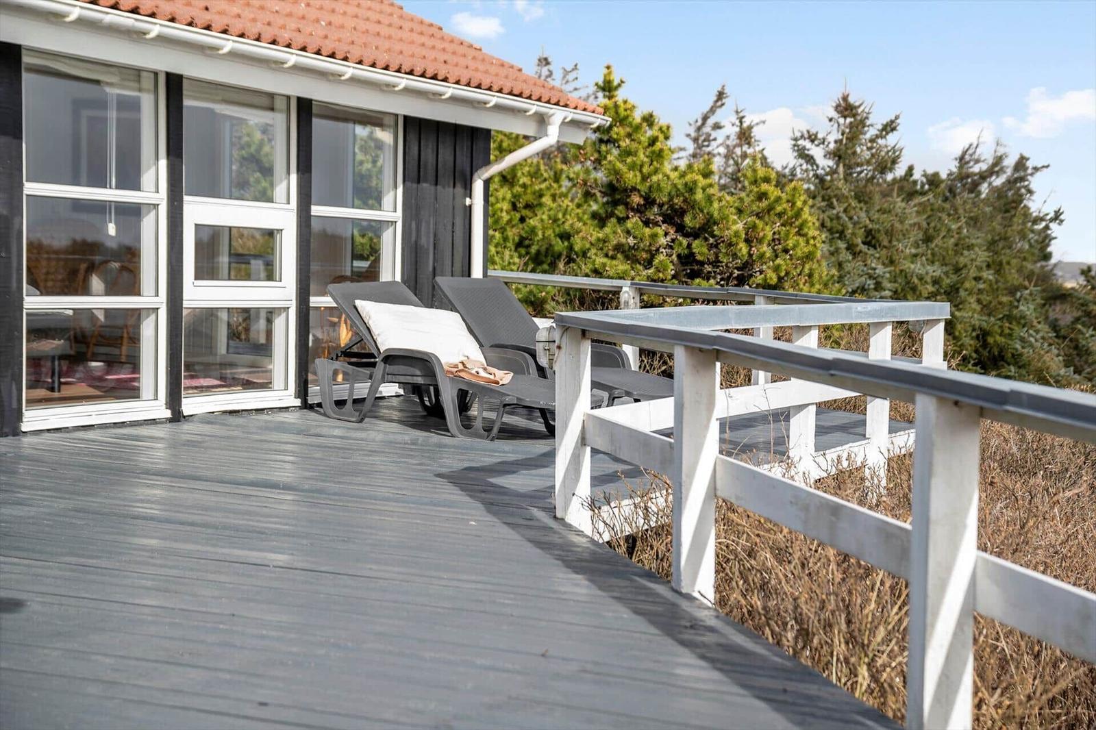 Terrasse mit Liegestühlen und Blick auf Grünflächen