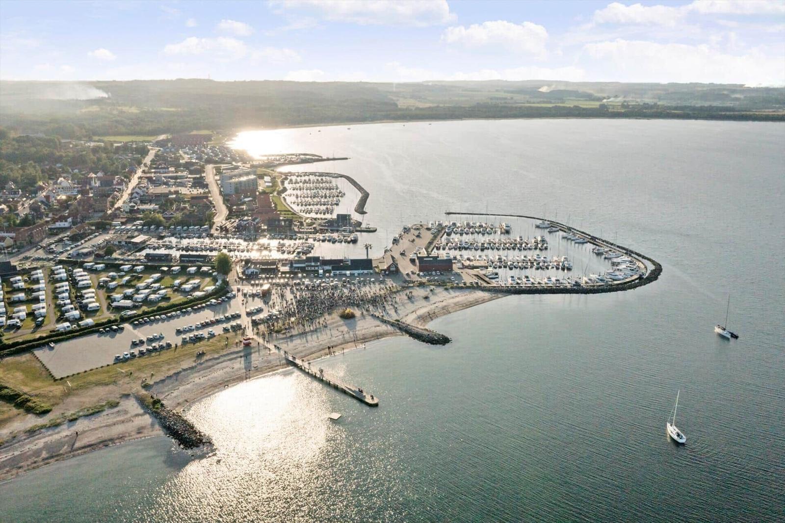 View of harbor with boats, beach, and residential areas along the coast.