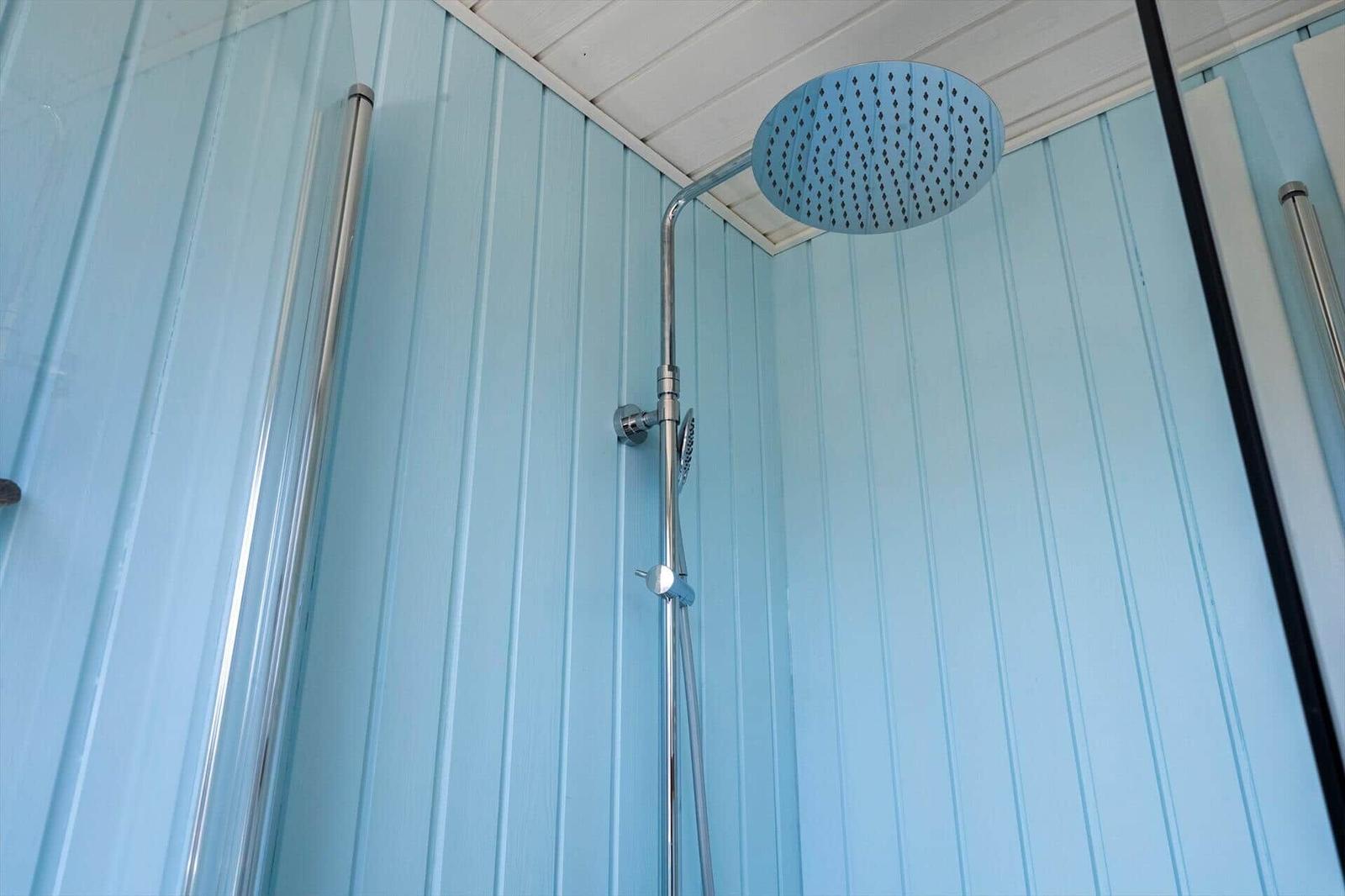 Duschkopf mit Regendusche und Handbrause an blauen Wänden