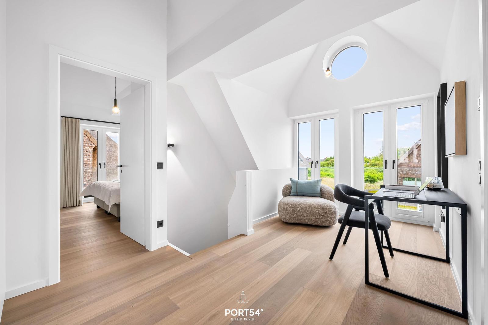 Schlafzimmer mit Blick auf Garten. Arbeitsplatz mit Tisch und Stuhl.