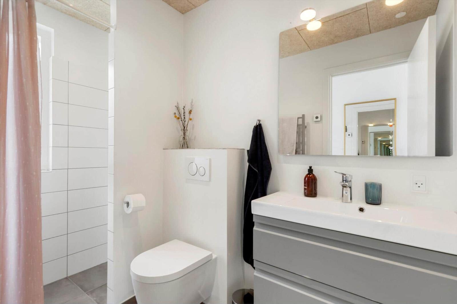 Badezimmer mit Toilette, Waschbecken und Dusche mit Duschvorhang.