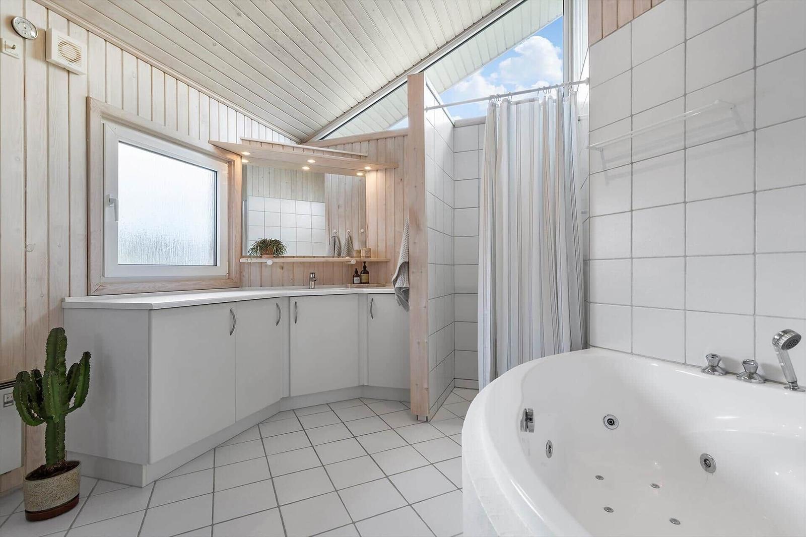 Badezimmer mit Dusche, Badewanne und Waschbecken mit Spiegel