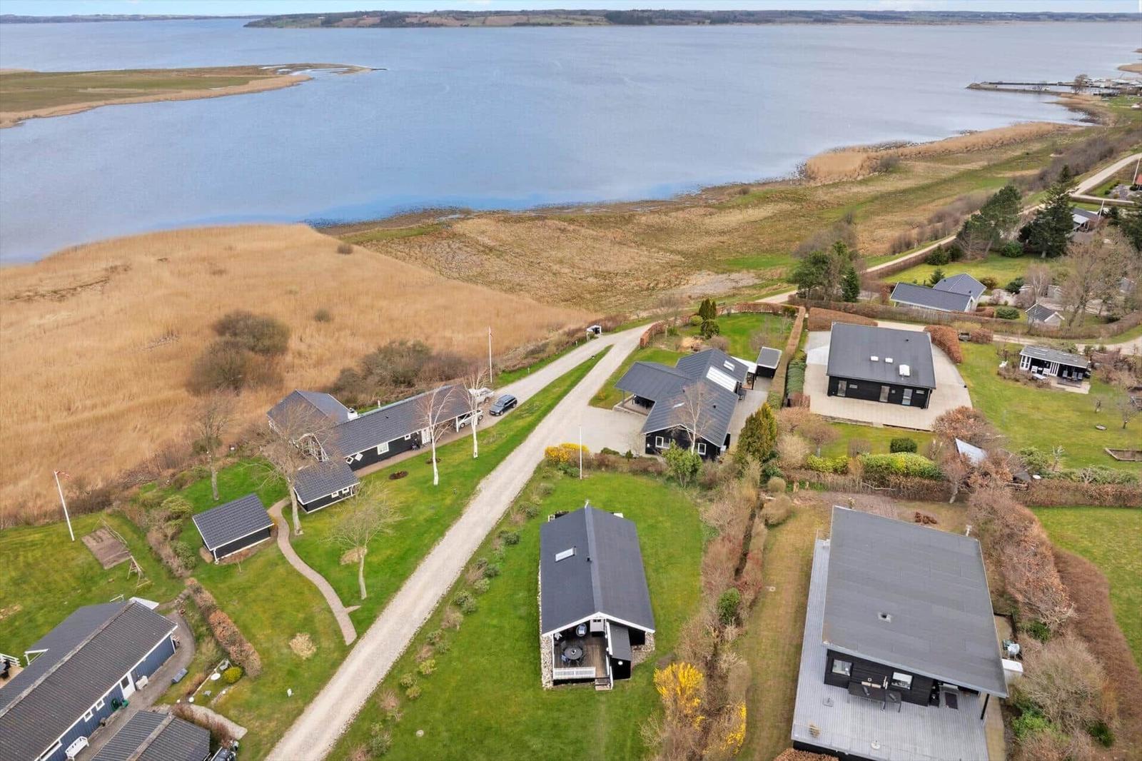 Houses by the water with green areas and forest