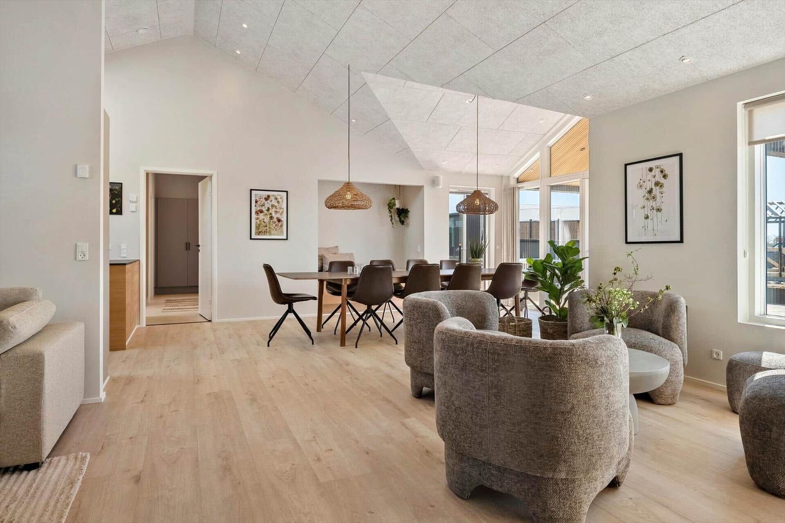 Living and dining area with wooden floor, seating group, and dining table. Ceiling with light opening.