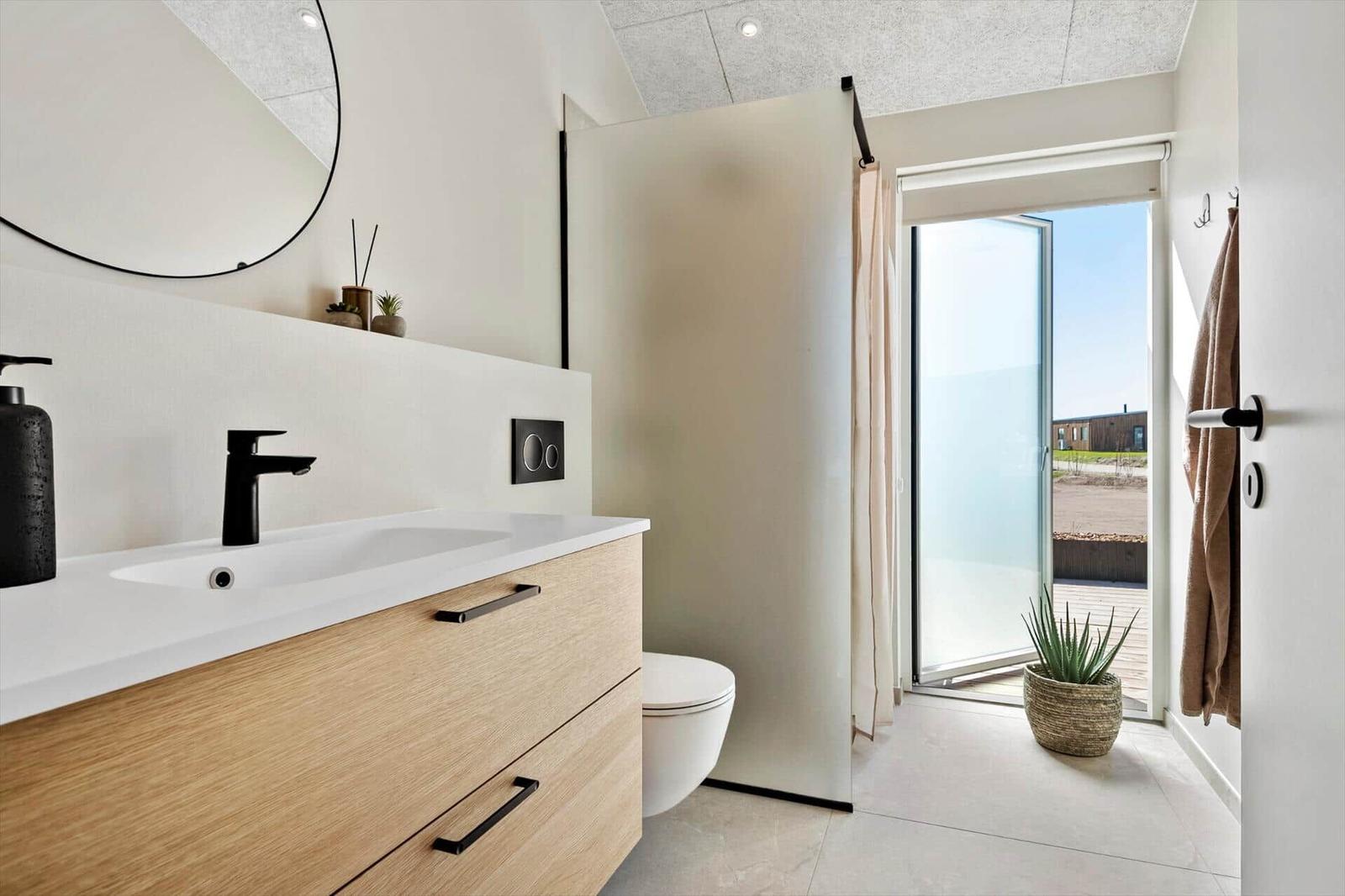 Bathroom with sink, toilet, and balcony access.