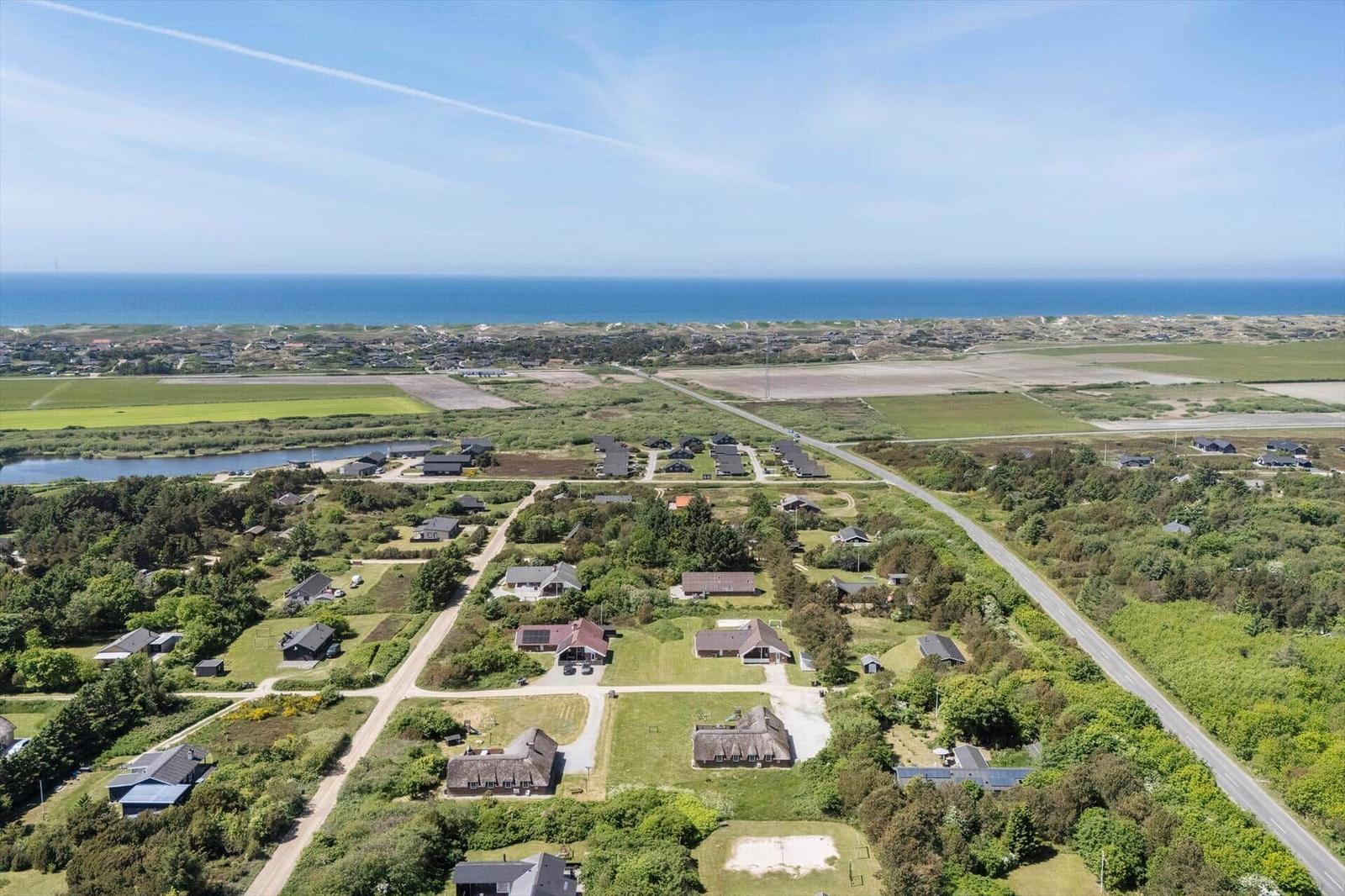 Luftbild von Ferienhäusern mit Grünflächen und Blick aufs Meer