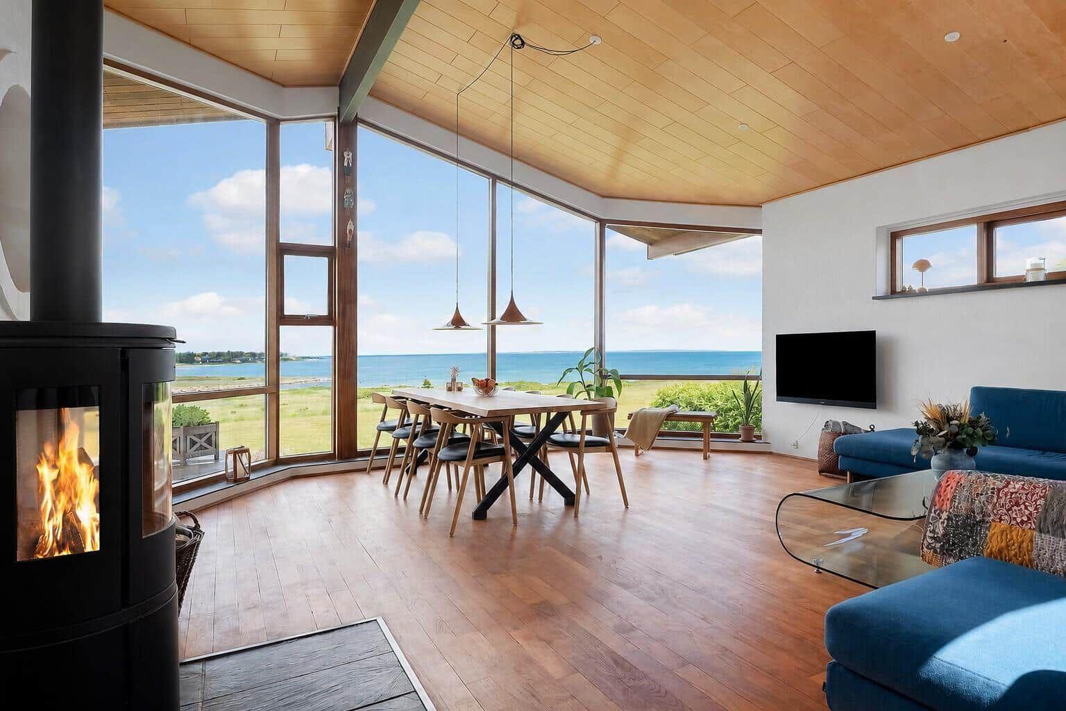 Living and dining area with sea view and fireplace.