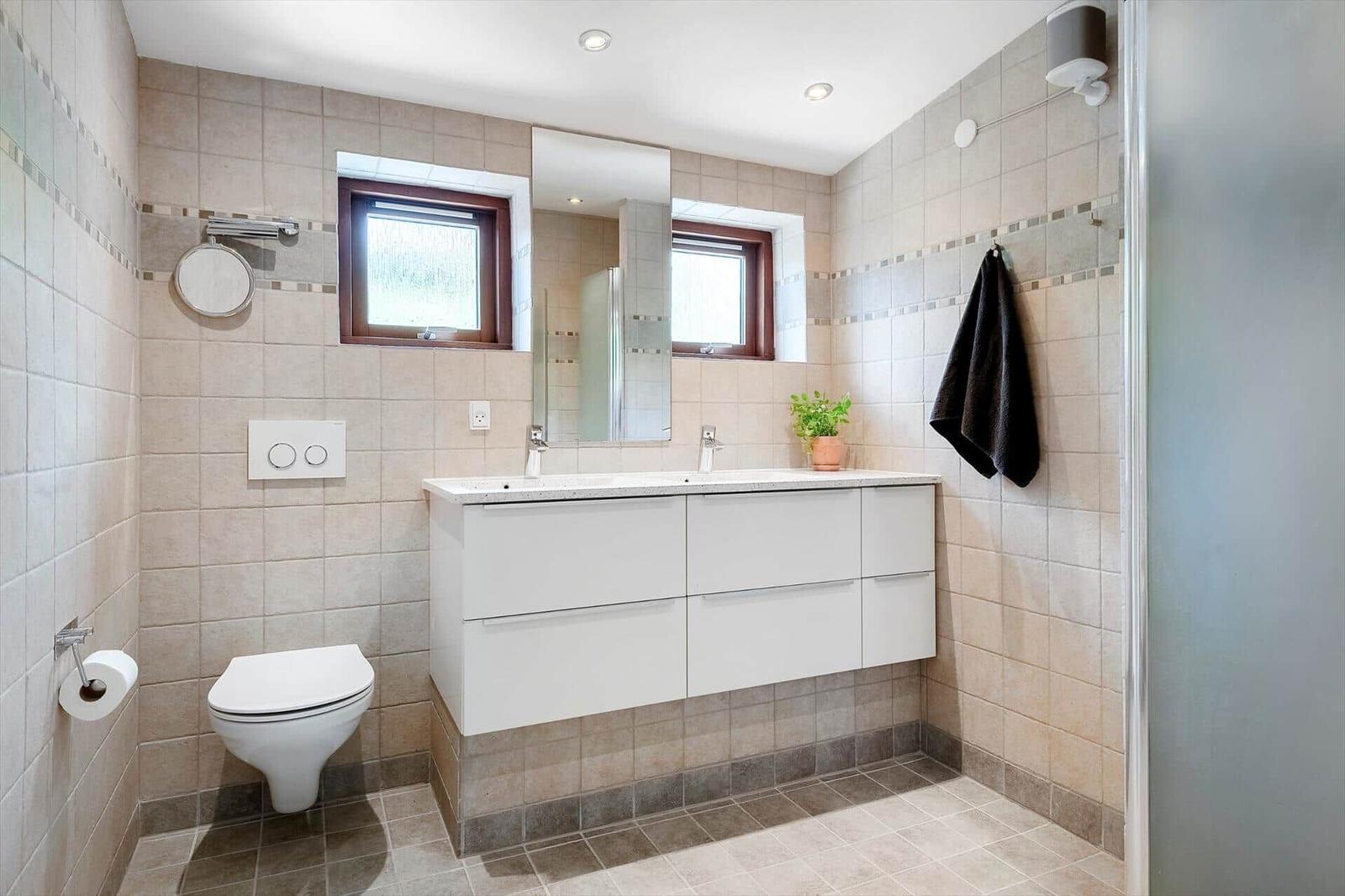 Bathroom with sink, mirror, toilet, and shower.