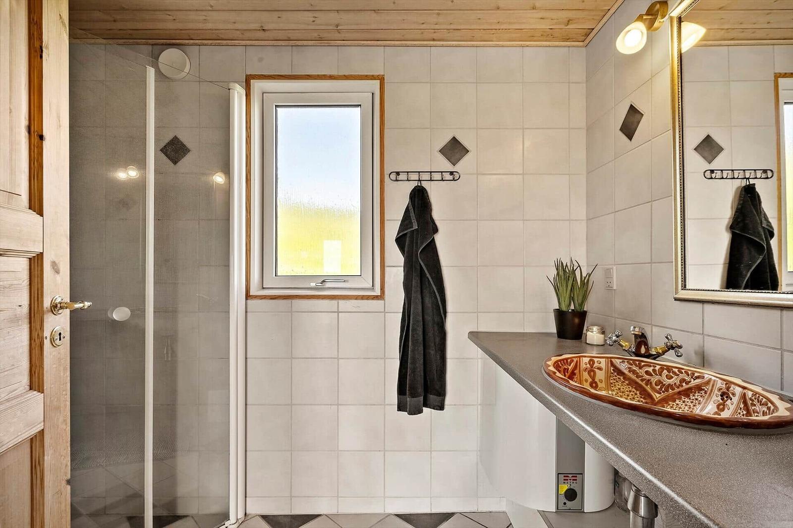 Badezimmer mit Dusche, Waschbecken und Fenster
