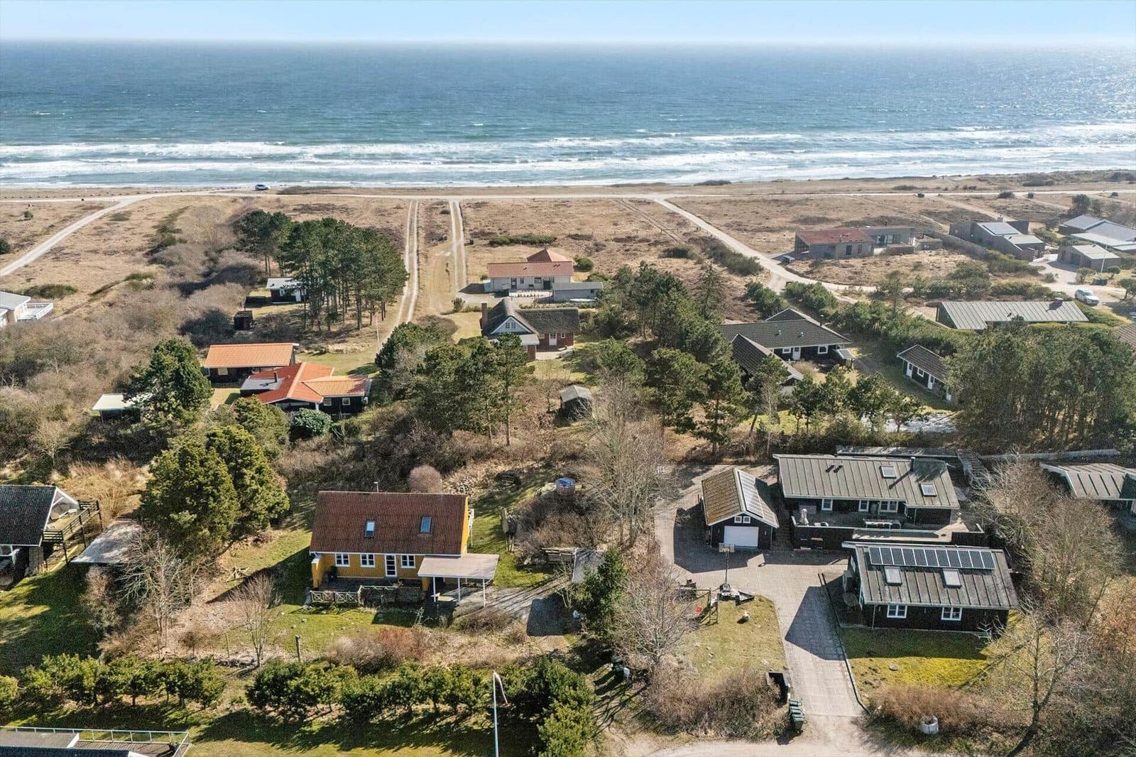 Übersicht über Strandhäuser mit Blick auf das Meer und Dünen.
