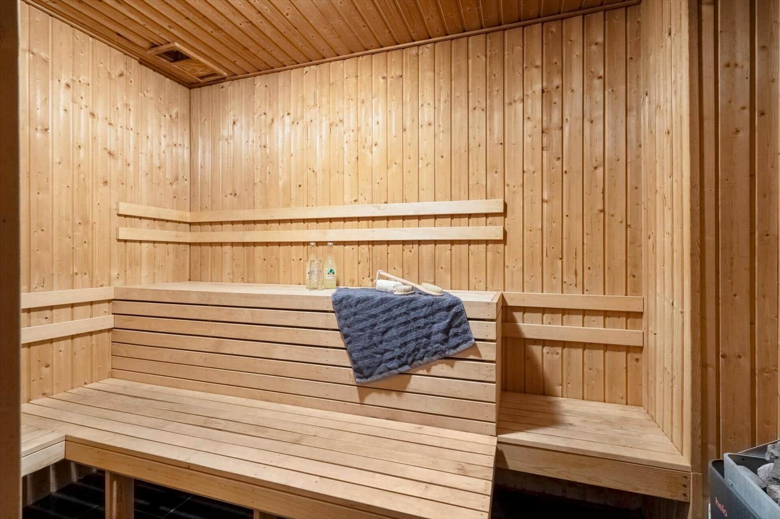 Holzsauna mit mehreren Sitzbänken und einem Handtuch.