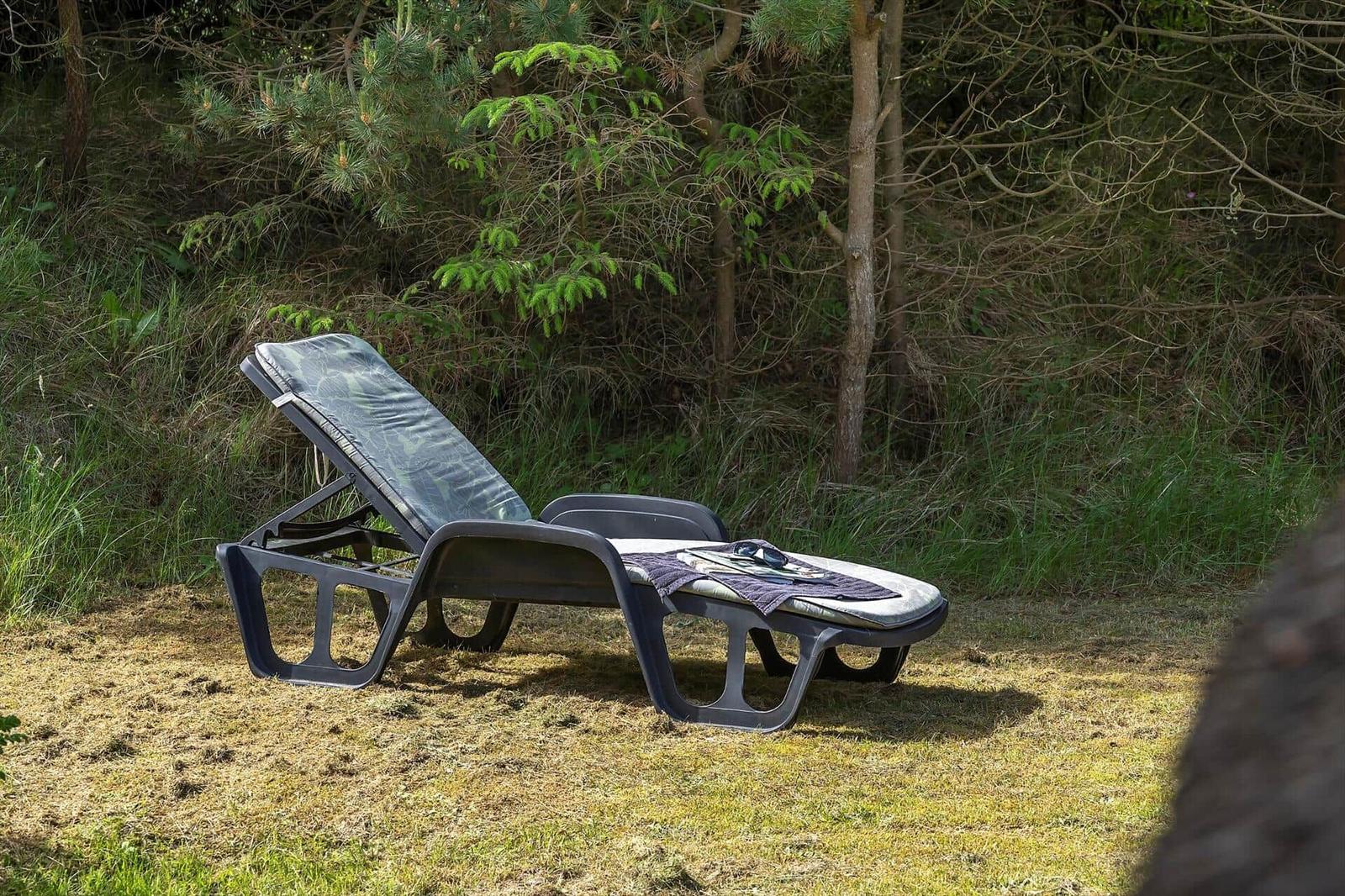 Liegestuhl im Grünen mit Decke und Sonnenbrille