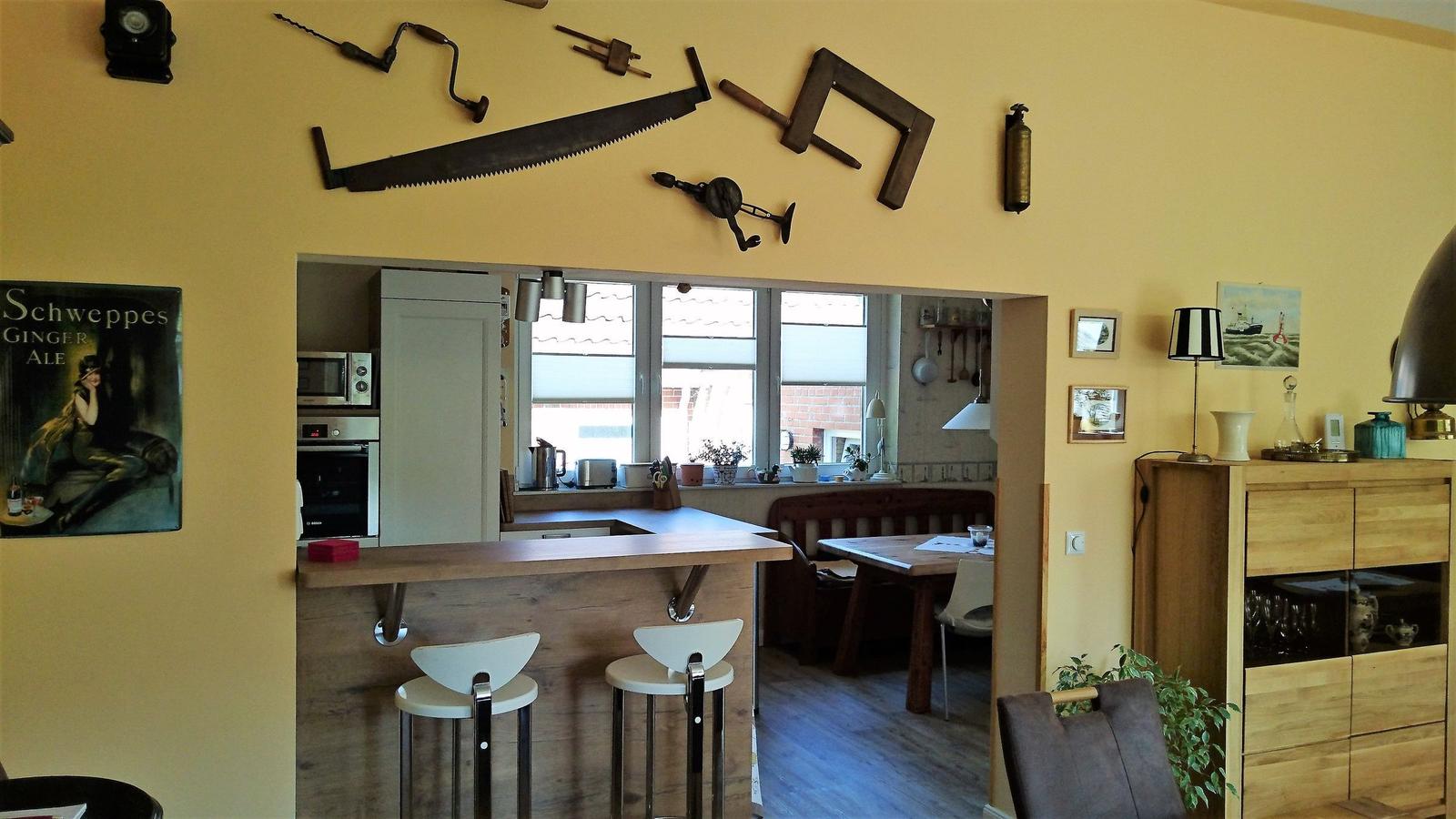 Küche mit Essbereich, Holzbar und Wanddekoration aus Werkzeugen.