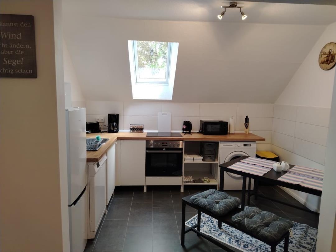 Küche mit Fenster, Spüle, Herd und Waschmaschine.