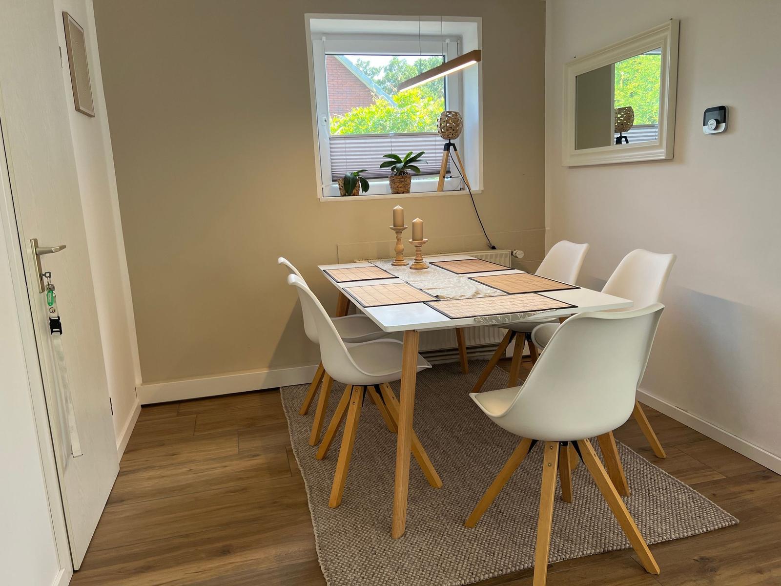 Esszimmer mit Tisch, Stühlen und Fensterblick